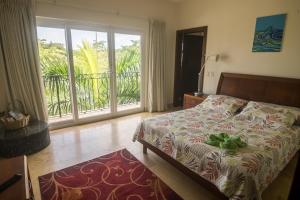 1 dormitorio con cama y vistas a un balcón en Acqua Residences 503, en Jacó