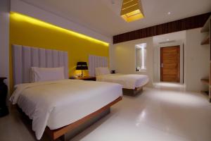 a bedroom with two beds and a yellow wall at Apsara Residence Hotel in Siem Reap