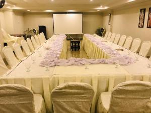 a long table in a room with white chairs at Hotel One Mall Road Murree in Murree