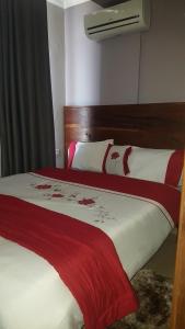 a bedroom with two beds with red and white sheets at Bml Highway Hotel in Dar es Salaam