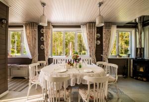 a dining room with a white table and chairs at Seasons in Drozdava