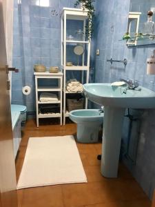 Baño azul con lavabo y aseo en Apartamento Laura, en Cee