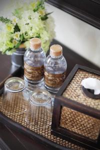 a tray with three bottles and glasses on a table at Rambuttri Village Plaza in Bangkok