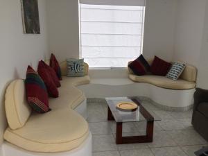 Sala de estar con 2 sofás y mesa de centro en Casa de playa, Palabitas, Asia del Sur, en Asia