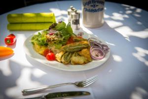 um prato de comida com uma salada na mesa em Brauerei und Gasthof zum Engel em Waldstetten