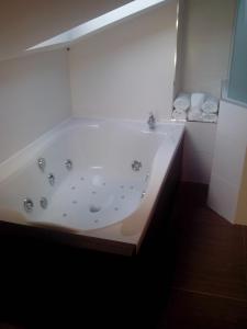 a white bath tub sitting next to a white sink at La Ermita in Brunete
