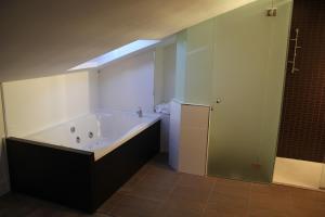 a bathroom with a tub, sink, and mirror at La Ermita in Brunete