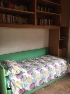 a bed in a room with a book shelf at La casa di Ale. Foligno in Colfiorito