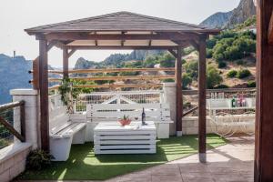 a wooden gazebo with a table and a bench at Alojamiento Rural Caminito del Rey in El Chorro