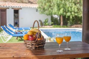 a basket of fruit and two glasses of wine on a table at Alojamiento Rural Caminito del Rey in El Chorro