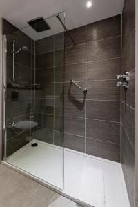a bathroom with a shower with a glass door at Gresham Belson Hotel Brussels in Brussels