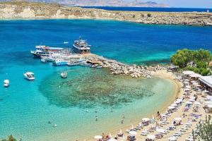 a beach with a group of people and boats in the water at Lindos Vigli Private Villa in Lindos