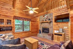 a living room with a fireplace and a tv at Friendly Bear Cabin in Pigeon Forge