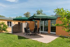 a patio with a table and chairs under umbrellas at An der Günz in Waldstetten