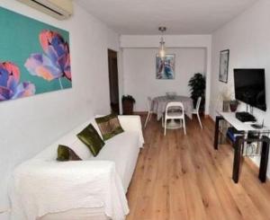 ein Wohnzimmer mit einem weißen Sofa und einem Tisch in der Unterkunft Ramon - Y - Cajal in Fuengirola