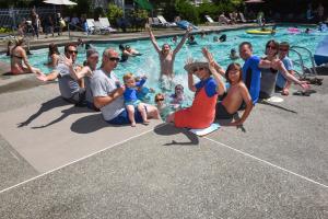 a group of people sitting around a swimming pool at Thunderbird One-Bedroom Cabin 6 in Monroe