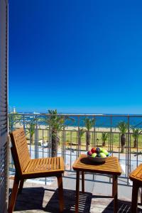 a chair and a bowl of fruit on a table on a balcony at Casa Maistra Residence in Rethymno