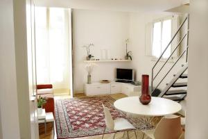 卡塔尼亞的住宿－Ognina Residence，白色的客厅设有桌子和楼梯