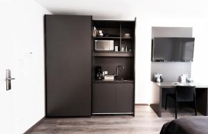 een kamer met een zwarte scheidingswand met een tafel en een tv bij Mood contemporary living in Mannheim