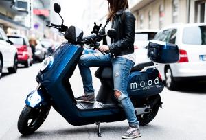 a woman sitting on a scooter on a street at Mood contemporary living in Mannheim