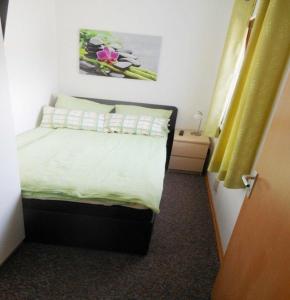 アルテンアウにあるFerienwohnung-Kaehlerのベッドルーム1室(黄色いカーテン付きのベッド1台付)