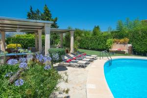 uma piscina com espreguiçadeiras e uma pérgola em Owl Booking Villa Coloma - Luxury Retreat with Huge Pool em Port de Pollença