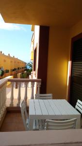 een witte tafel en stoelen op een balkon bij APARTAMENTOS EL CIENO in La Playa Calera