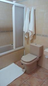 een badkamer met een toilet, een bad en handdoeken bij APARTAMENTOS EL CIENO in La Playa Calera