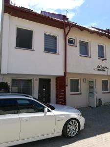 een witte auto geparkeerd voor een huis bij Deima in Nida