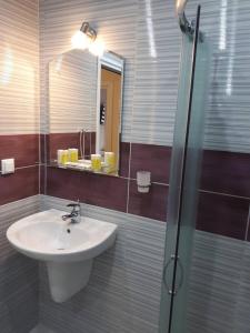 a bathroom with a sink and a shower with a mirror at CAPUCCINO GUEST APARTMENTS - FREE PARKING and Wi-Fi in Sunny Beach