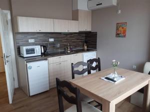 uma cozinha com uma mesa de madeira e um micro-ondas em CAPUCCINO GUEST APARTMENTS - FREE PARKING and Wi-Fi em Sunny Beach