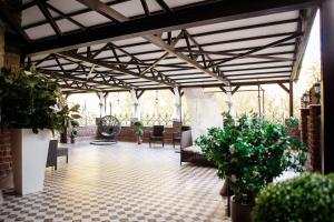 チュメニにあるGreen House Hotel Tyumenのパティオ(椅子、鉢植えの植物付)