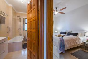 プエルト・デ・サンティアゴにあるSunset Suiteのベッドルーム1室(ベッド1台付)、バスルーム(バスタブ付)が備わります。