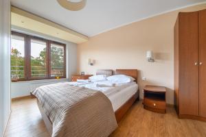 1 dormitorio con cama grande y ventana grande en Apartamenty Sun & Snow Żeromskiego Krynica Morska, en Krynica Morska