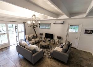 a living room with two couches and a tv at Valmont Estate in Plettenberg Bay