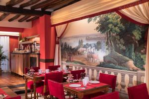 une salle à manger avec un grand tableau mural dans l'établissement Hotel Des Deux Continents, à Paris