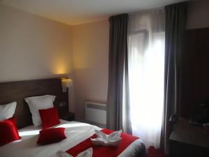a bedroom with a bed with red pillows and a window at Hotel la Perle Montparnasse in Paris