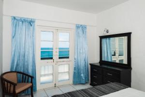 a bedroom with a mirror and a dresser and a window at Santorini - Perissa 22 in Ballito