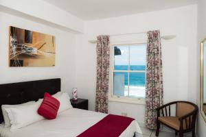 a bedroom with a bed and a window with the ocean at Santorini - Perissa 22 in Ballito