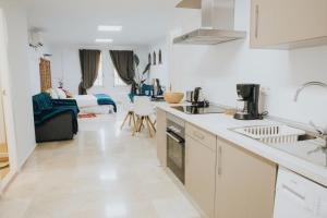 cocina con armarios blancos y sala de estar. en Home Bassou, en Santa Cruz de Tenerife