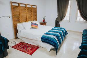 een slaapkamer met een wit bed en een houten hoofdeinde bij Home Bassou in Santa Cruz de Tenerife