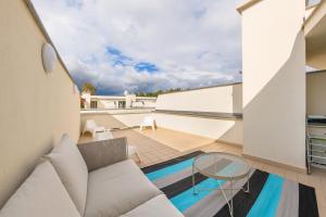 a balcony with a couch and a glass table at Bursztynowe Osiedle Jantar, Sun & Snow in Jantar