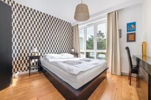 a bedroom with a bed and a large window at Bursztynowe Osiedle Jantar, Sun & Snow in Jantar