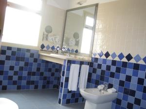 a blue and white bathroom with a sink and a toilet at Hotel Sierra Luz in Cortegana