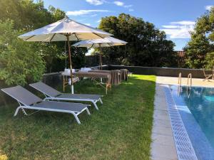 a group of chairs and umbrellas next to a pool at Quinta de Santa Clara in Ponta Delgada