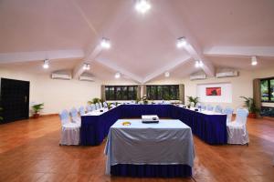 a large room with blue tables and white chairs at Toshali Sands Puri in Puri