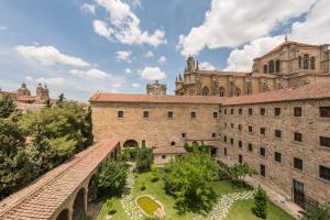 un vieux bâtiment avec un pont devant lui dans l'établissement Hospes Palacio de San Esteban, à Salamanque