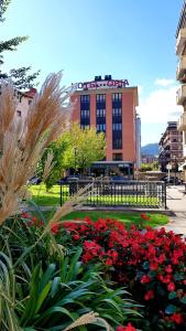 un parco con fiori rossi di fronte a un edificio di Hotel Oria a Tolosa