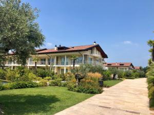 a large house with a garden in front of it at Deluxe Apartments Garda in Sirmione