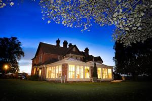 a large brick house with lit up windows at The Old Vicarage in Bridgnorth